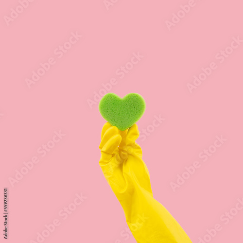Fotografia Heart shape green sponge and yellow rubber gloves on pink background