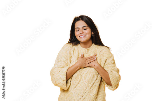 Photography Young pretty caucasian woman wearing a yellow jumper, laughing keeping hands on heart, concept of happiness