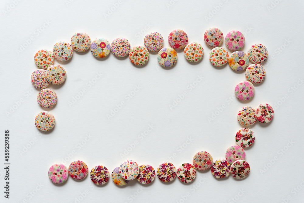 frame composed of decorative crafting buttons on plain paper frame composed of decorative crafting buttons on plain paper