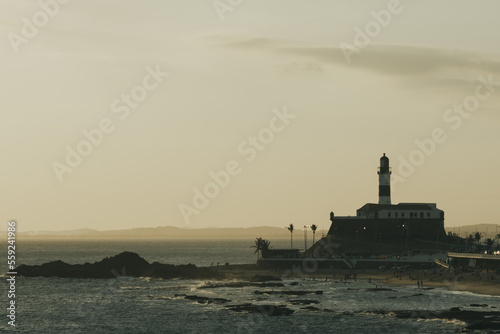 BArra's lighthouse in an almost vintage sunset with view to the itaparica island behind. Afternoon in salvador, Bahia.  photo
