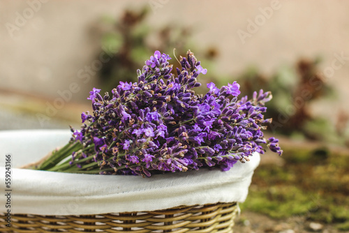 Lavender bouquet in a wicker basket with white cotton liner on blurry background