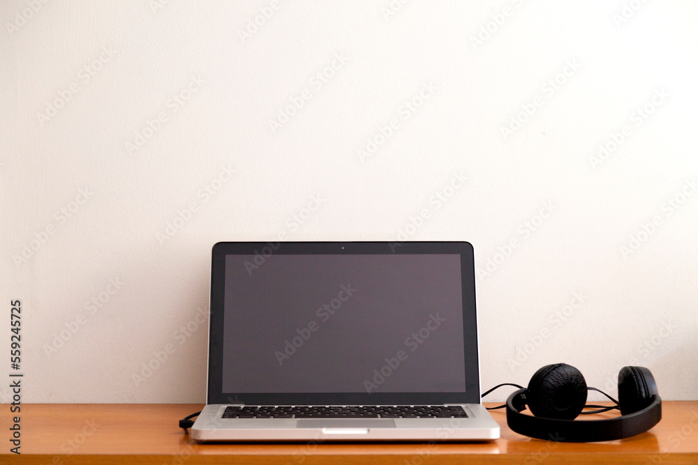 Notebook on a table with wired headphones. Podcast. Streaming. Notebook concept. Headphone concept. Notebook on a table with wired headphones. Podcast. Streaming. Notebook concept. Headphone concept.