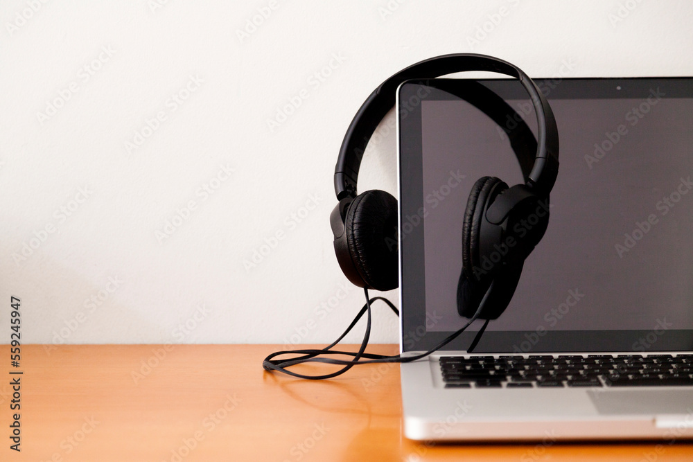 Notebook on a table with wired headphones. Podcast. Streaming. Notebook concept. Headphone concept. Notebook on a table with wired headphones. Podcast. Streaming. Notebook concept. Headphone concept.