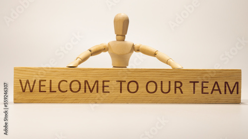 Welcome to our team is written on the wooden surface. Wooden Concept