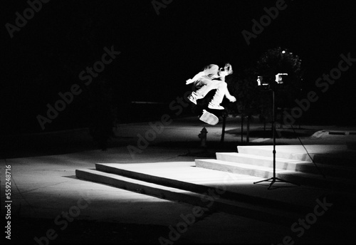 Lighting up the pitch darkness capturing the entire frame of the skateboarder frontside flipping a double set.