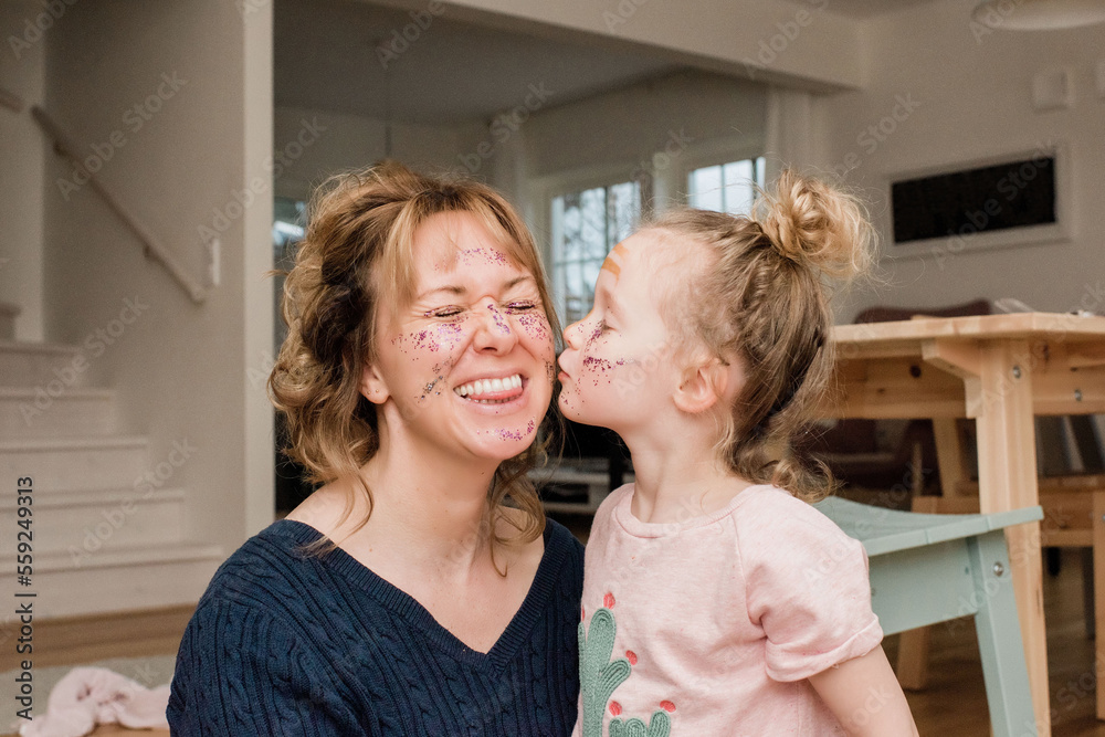 mother and daughter playing with make up at home laughing together mother and daughter playing with make up at home laughing together