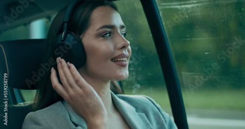 Buisnees woman in car wearing wireless headphones speaks by phone having call from colleagues. Calm woman pressing sounds relived girl heading meeting appointment .