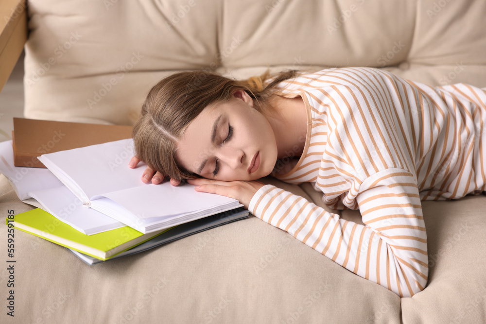 Young tired woman sleeping near books on couch Young tired woman sleeping near books on couch