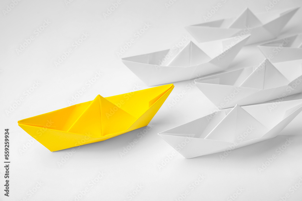 Group of paper boats following yellow one on white background. Leadership concept Group of paper boats following yellow one on white background. Leadership concept