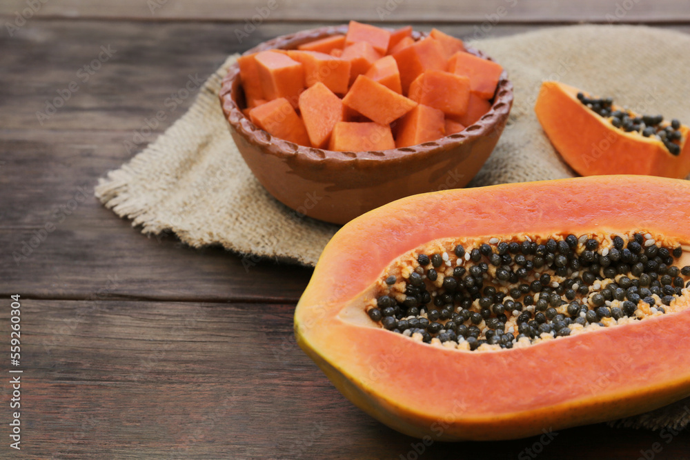Tasty ripe cut papaya fruits on wooden table, closeup Tasty ripe cut papaya fruits on wooden table, closeup
