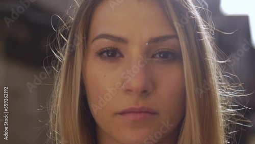 A young blonde woman looks at the camera. Dordogne, Issigeac - France photo