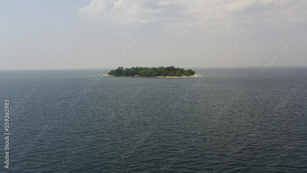 Tropical island with a beach in the open ocean. Putipot island, Philippines.