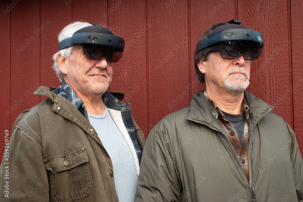 Fototapeta premium Two men wearing virtual reality goggles, outdoors. 