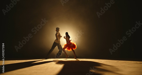 Obraz na płótnie Talented asian kids showing ballroom dance on stage, on smoked black background