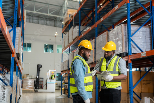 Принти на полотні African male workers interact in a factory warehouse for export business