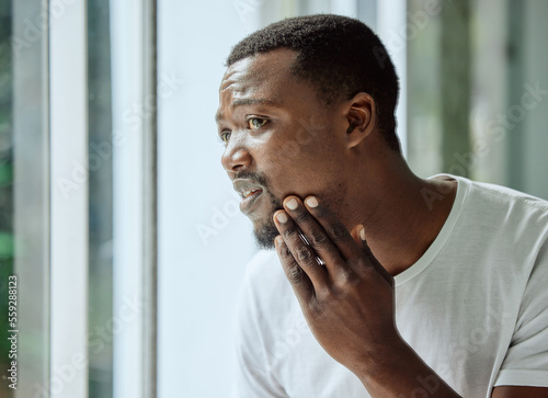 Skincare, black man and acne stress at mirror in home bathroom with worried and confused face. Unhappy man checking pimple and blackhead problem in reflection with morning grooming routine.