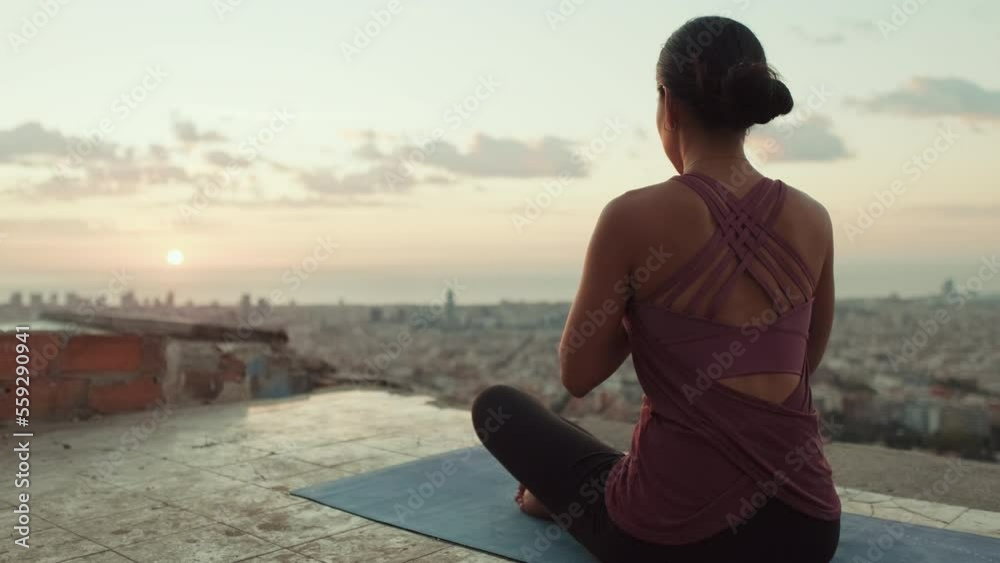 Girl meditates sitting on the observation deck at dawn Girl meditates sitting on the observation deck at dawn
