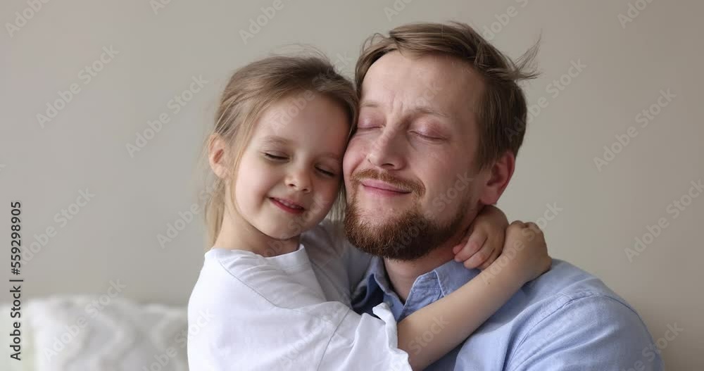 Close up portrait loving father and little cute daughter touch faces with eyes closed enjoy moment of tenderness, feeling unconditional love and bond, spend priceless time together. Happy fatherhood