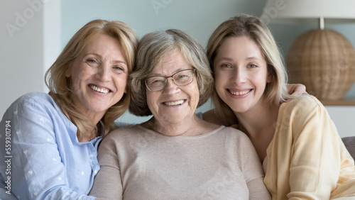 Foto Cheerful pretty women of different ages, generations sitting close together, loo