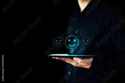 Hand of businessman holding tablet showing to rating score happy icons. Customer service experience and business satisfaction survey concept