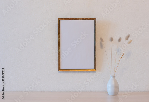 Template with photo frame on a wooden table. Bouquet of Lagurus.