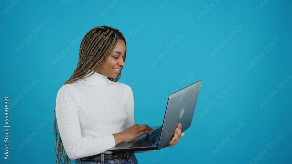 Happy african woman standing while using a laptop Happy african woman standing while using a laptop