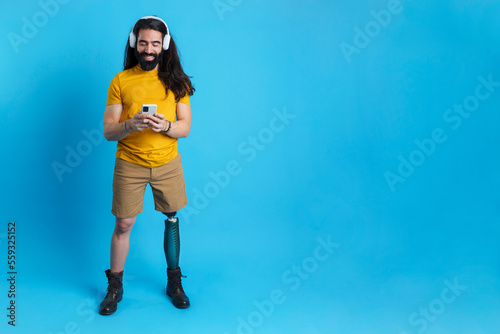 Man with leg prosthesis listening to music with the mobile