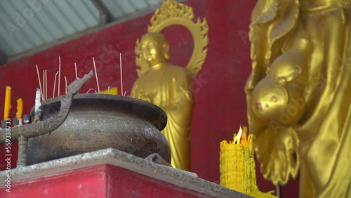 A candle burns in the Budi temple
