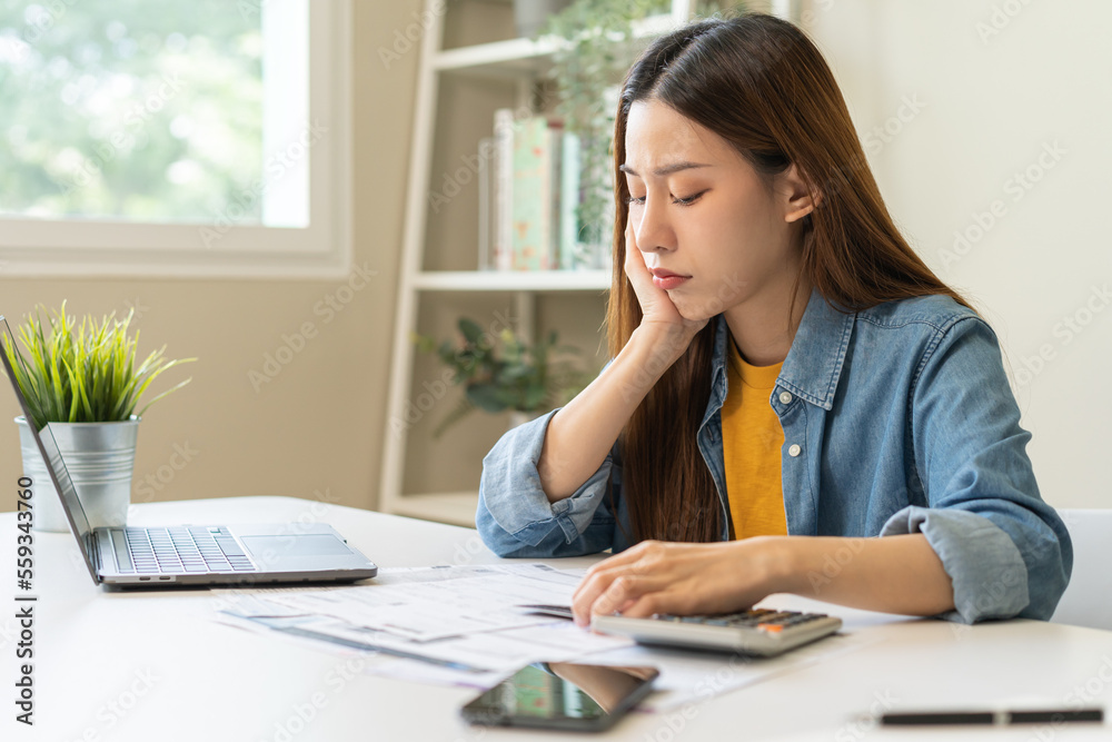 Financial owe, hand of asian woman sitting, holding credit card, stressed by calculate expense from invoice or bill, no money to pay, mortgage or loan. Debt, bankruptcy or bankrupt. Financial owe, hand of asian woman sitting, holding credit card, stressed by calculate expense from invoice or bill, no money to pay, mortgage or loan. Debt, bankruptcy or bankrupt.