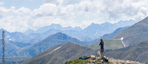 Woman enjoying beautiful view on mountain ranges from mountain summit, Slovakia, Europe