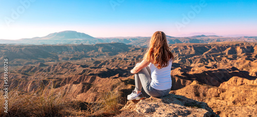 Foto Woman sitting and looking at sunset Gorafe desert in Spain