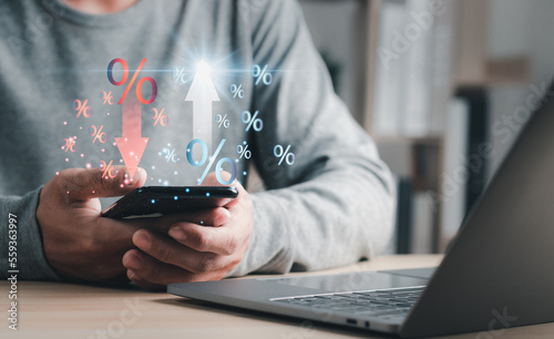Businessman with percentage icon and up and down arrow icon with graph indicator on virtual interface. Concept of financial interest rates and mortgage rates.