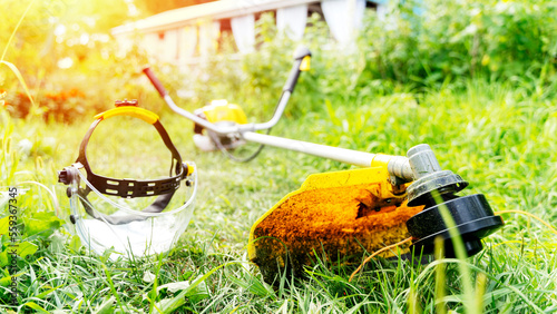 a man mows grass with a trimmer photo