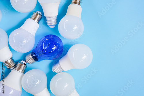 Top view of pile of white and blue light bulb on light blue background , unique and differentiation concept with copy space photo