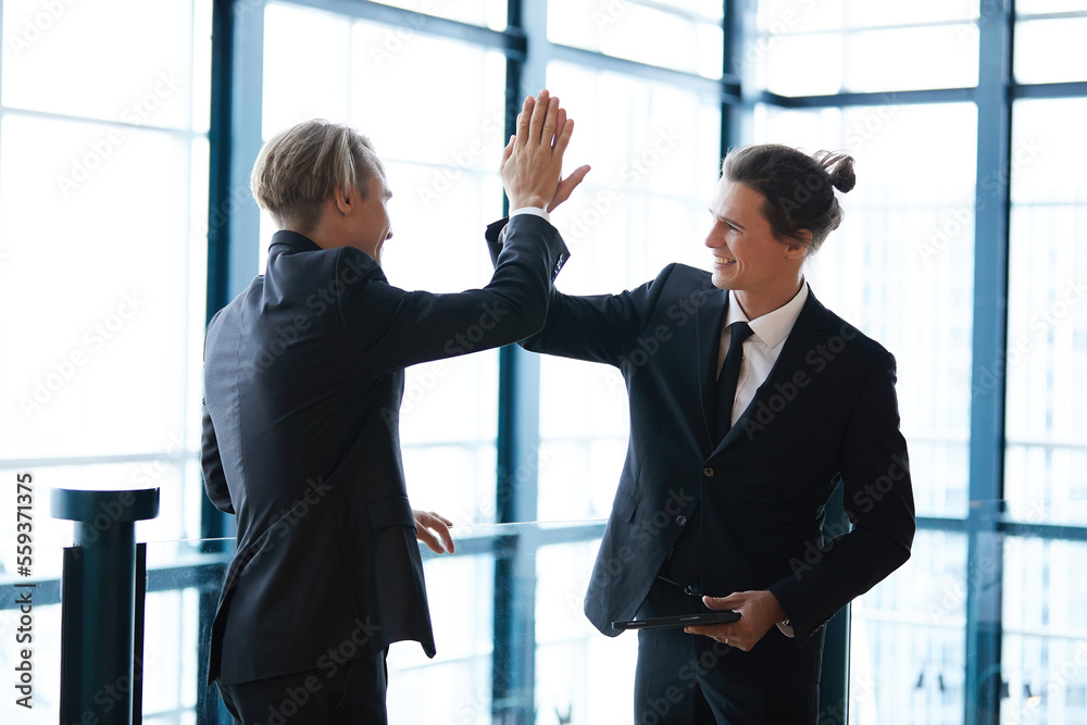 businessman giving hi five pose for success at work with friends and having fun in the office businessman giving hi five pose for success at work with friends and having fun in the office