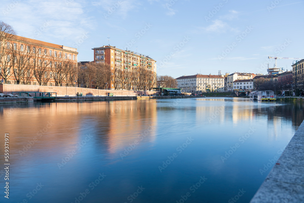 Milan,Italy-January 05,2023:People walk along the shore of the Naviglio Milanese canal and relax in the pubs,Milan,Italy.