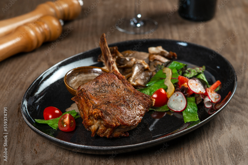 grilled beef steak with vegetables and spices on wooden table