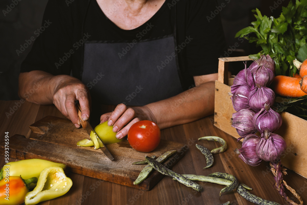 woman cutting vegetables on wooden board woman cutting vegetables on wooden board