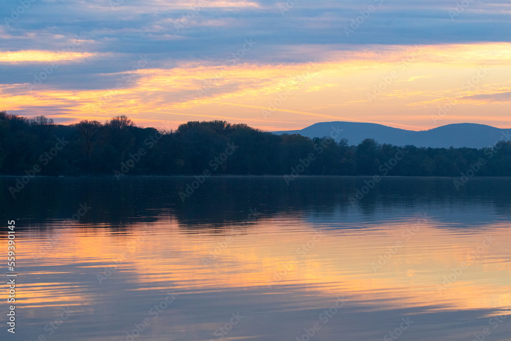 Beautiful landscape, sunsett on the river Danube Hungary with colorful sky reflection