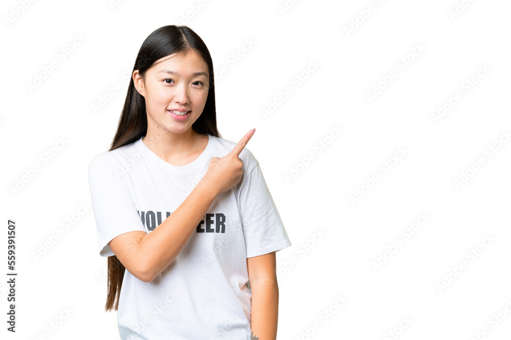 Young volunteer woman over isolated chroma key background pointing to the side to present a product Young volunteer woman over isolated chroma key background pointing to the side to present a product