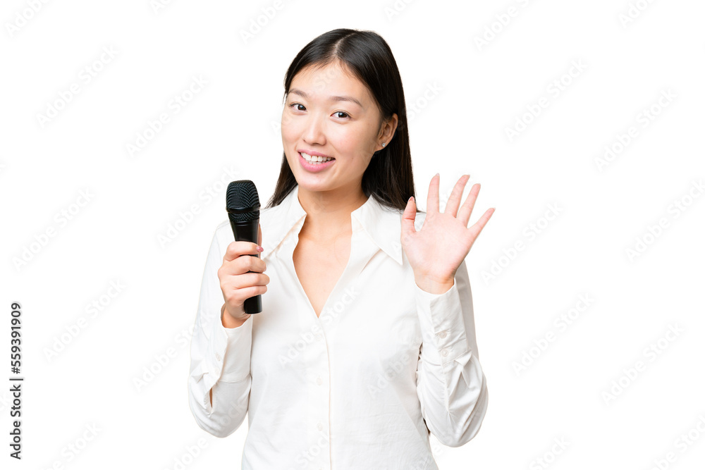 Singer picking up a microphone over isolated chroma key background saluting with hand with happy expression Singer picking up a microphone over isolated chroma key background saluting with hand with happy expression