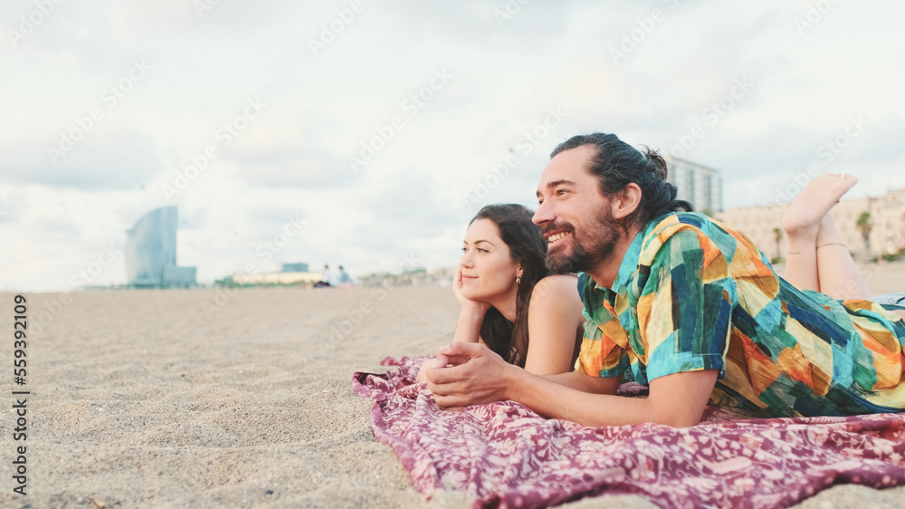 Man and woman talking and relaxing on blanket on the beach Man and woman talking and relaxing on blanket on the beach