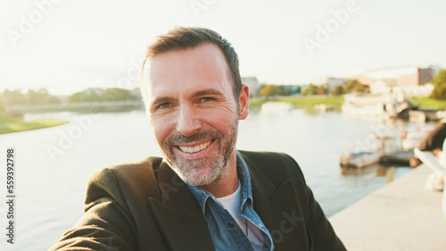 Photos Close up, man makes selfie on mobile phone on the embankment of the river