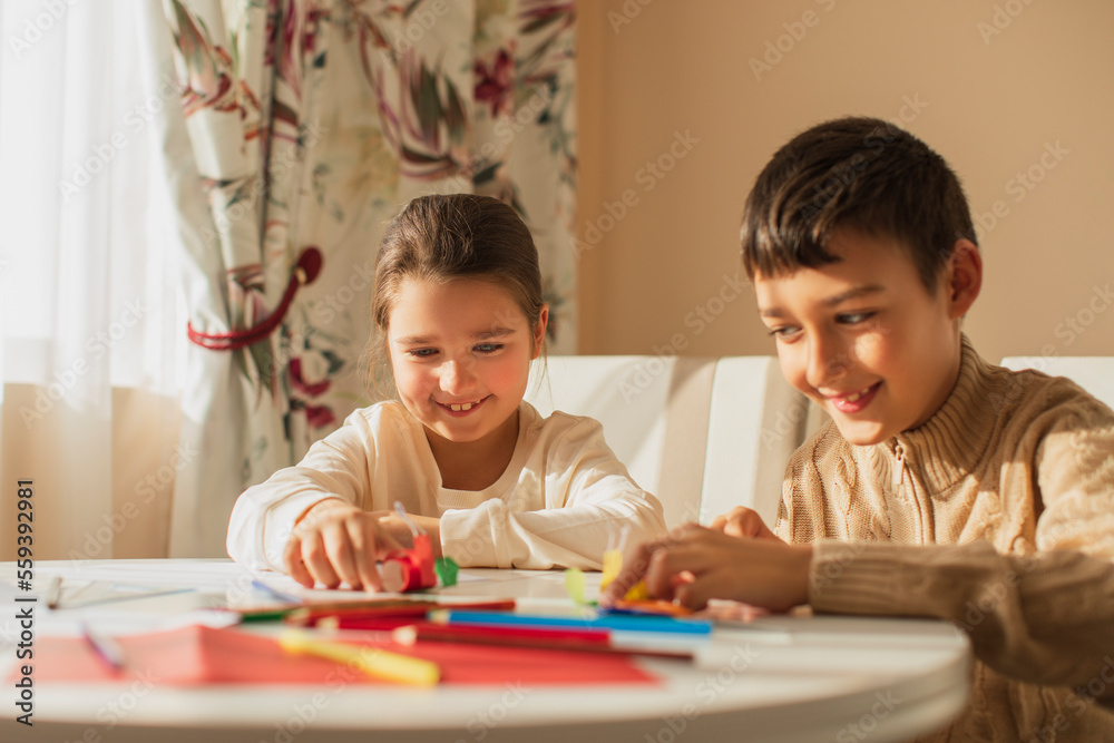 children draw with pencils and make crafts from colored paper children draw with pencils and make crafts from colored paper