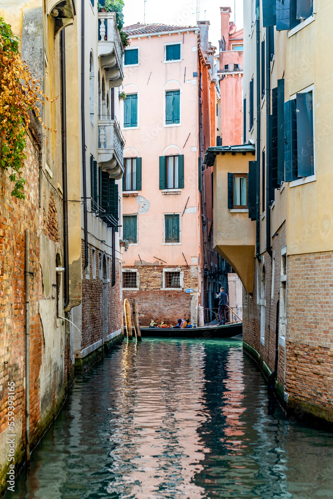 A narrow canal in Venice, near Sotoportego degli Armeni, with a gondola and tourists in the background, Venice city center, Veneto region, Italy