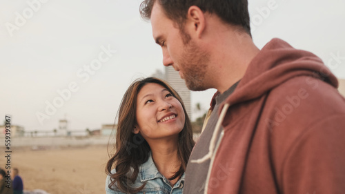 vMan and woman talking while standing on the beach