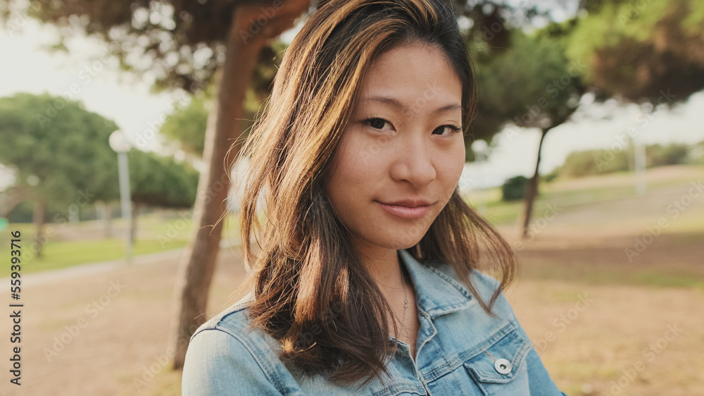 Close up, young woman posing at camera while standing in park. Looking at camera Close up, young woman posing at camera while standing in park. Looking at camera