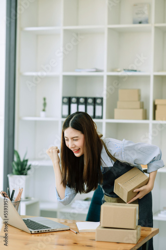 Asian woman SME working with a box at home the workplace.start-up small business owner, small business entrepreneur SME and delivery concept.