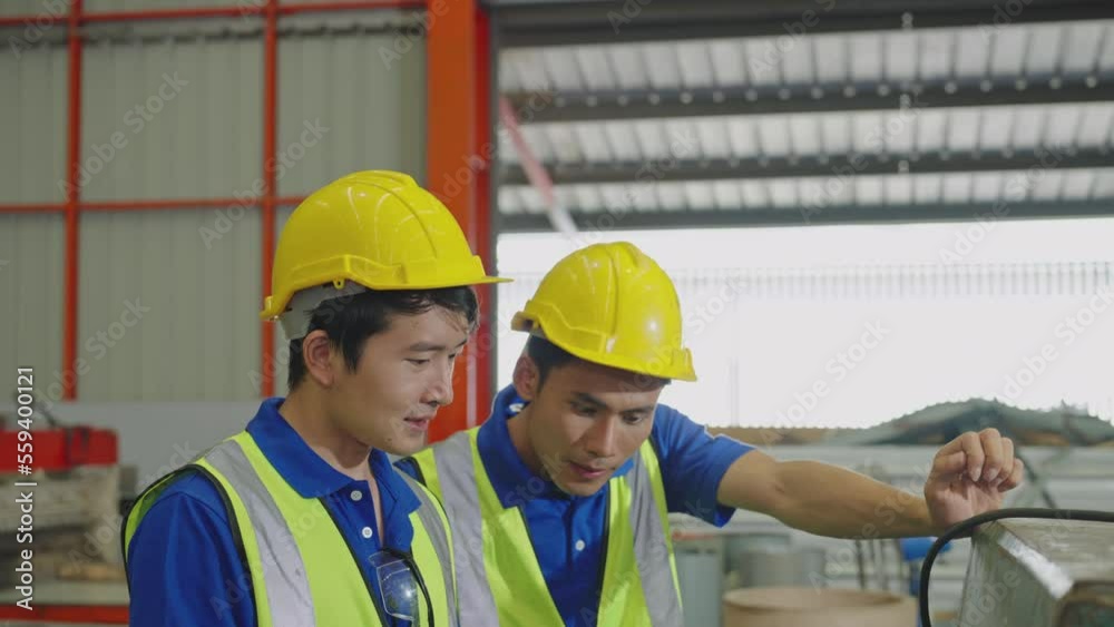 Two workers using a tablet computer in a factory Two workers using a tablet computer in a factory