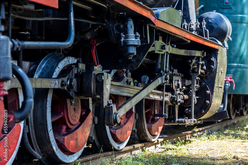 Close-up of the driving wheels of a steam locomotive. Steam locomotive parked on the forest station.